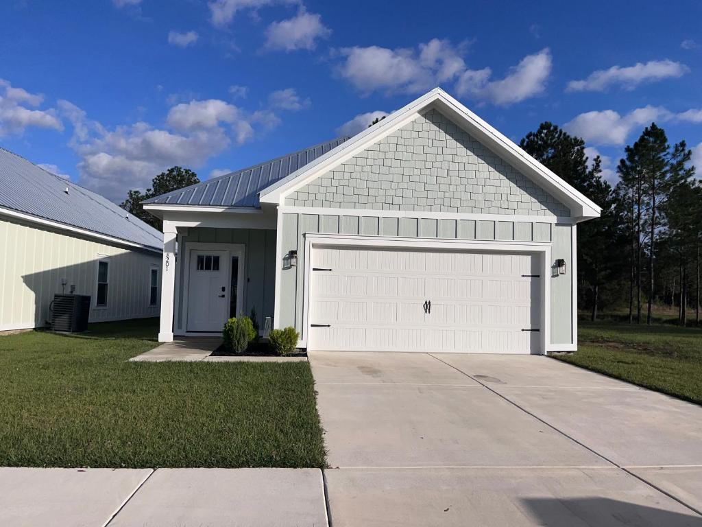 ein weißes Haus mit einer großen weißen Garage in der Unterkunft Beachy cottage near Sports Complex OWA beaches shopping restaurants mini golf Central to all the fun Foley has to offer in Foley