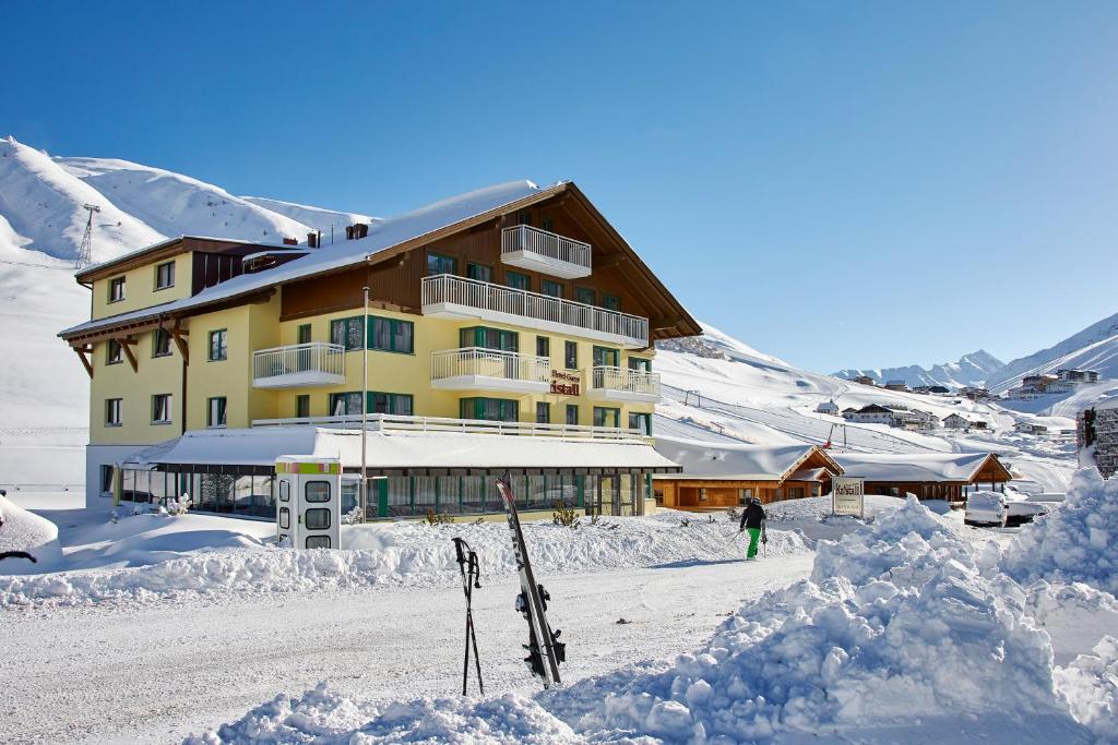 a building in the snow with skis in front of it at Hotel Garni Kristall in Kühtai