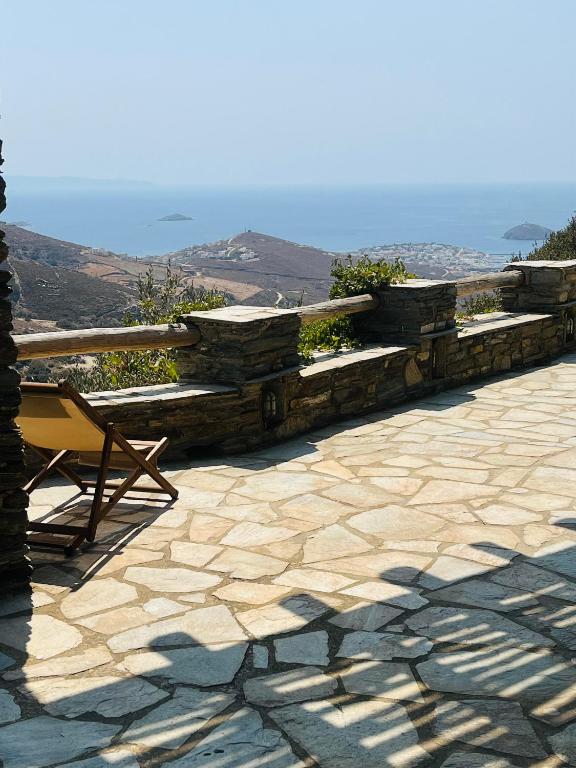 a stone wall with a bench and a chair on a patio at Anastasia Luxury Villas in Gavrio