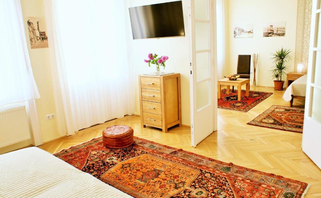 ブダペストにあるSuperCentral Apartmentのベッドとドレッサー付きの部屋、ラグ付きのベッドルームが備わる客室です。