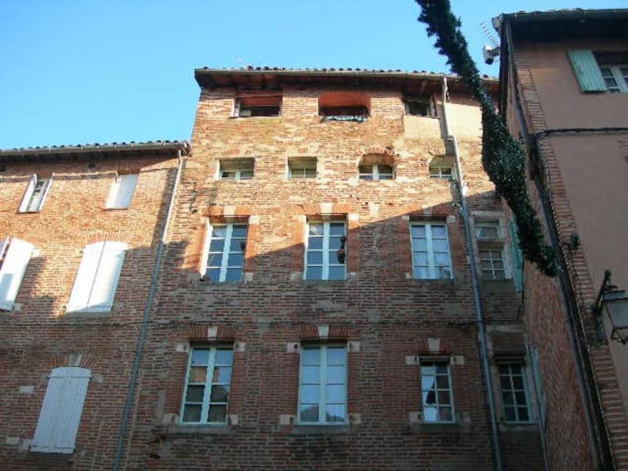 un grand bâtiment en briques avec de nombreuses fenêtres dans l'établissement Appartement Centre Historique 2 personnes, à Albi