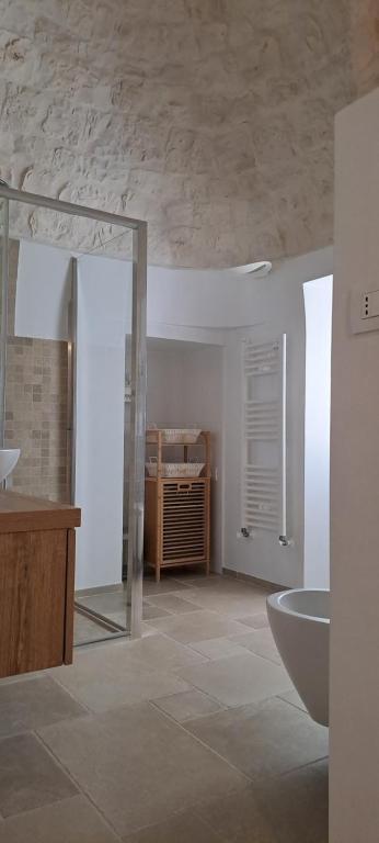 une salle de bain blanche avec un lavabo et une baignoire dans l'établissement Trullo Ritunno, à Locorotondo