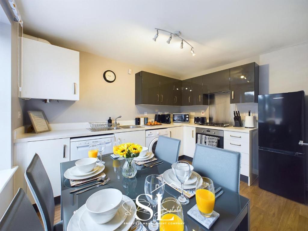 a kitchen with a dining table with chairs and a black refrigerator at Modern 3 bed Willenhall House in Willenhall