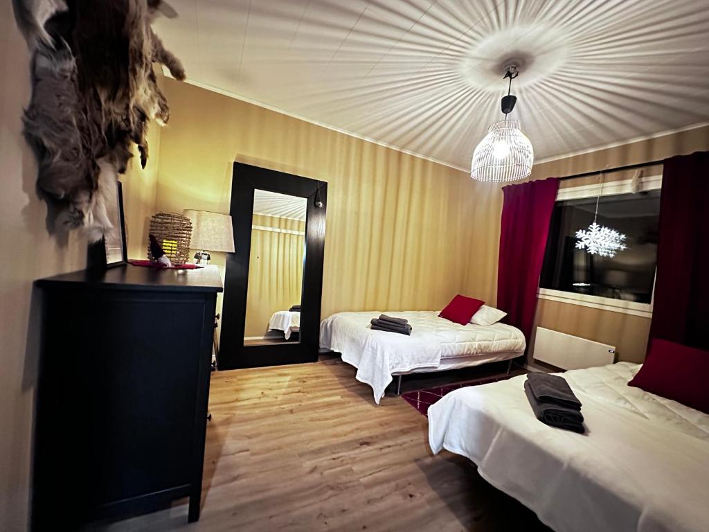 Una habitación de hotel con dos camas y un espejo. en Reindeer Nest, en Rovaniemi