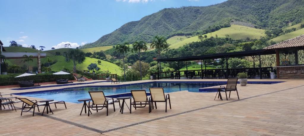 una piscina con sedie e tavolo e un edificio di Hotel Chalés Capitanias ad Águas de Lindóia