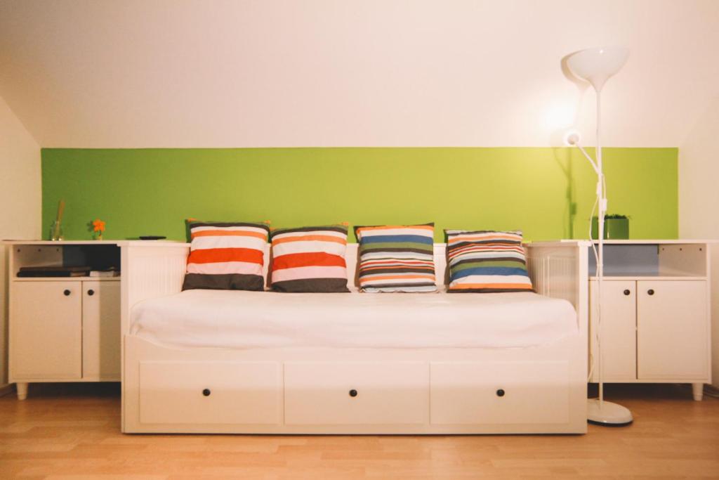 a bedroom with a white bed with a green wall at Apartments Sasha in Bled