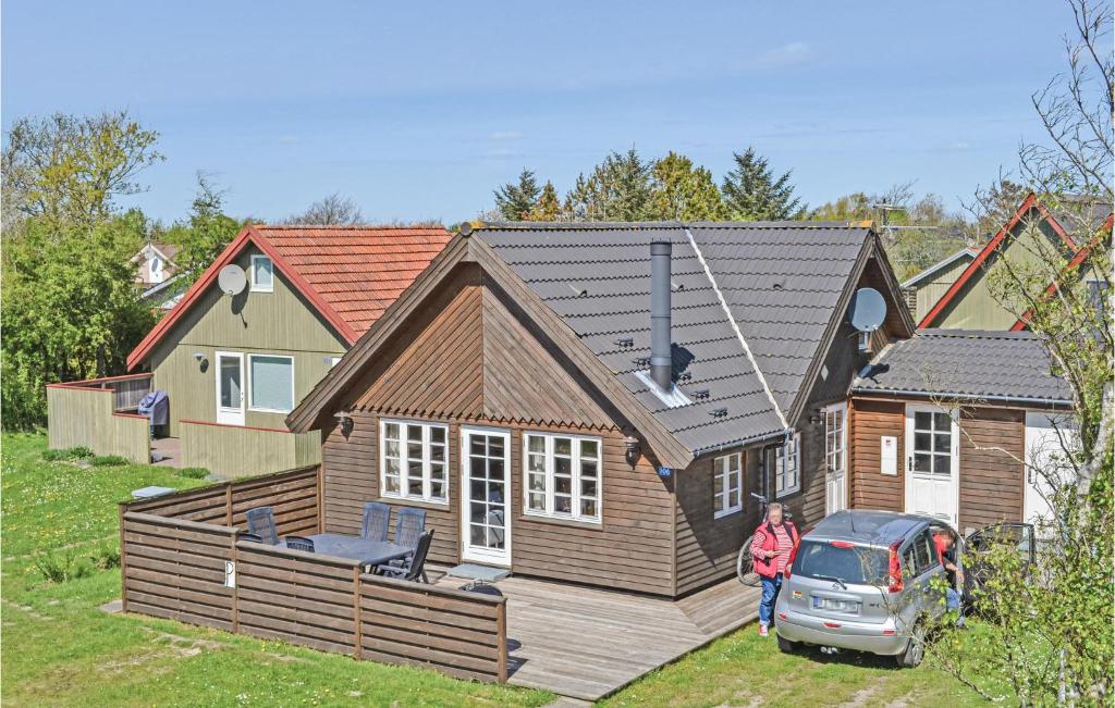 a woman is standing in front of a house at Holiday Home Bork Hytteby Hemmet Denmark in Falen