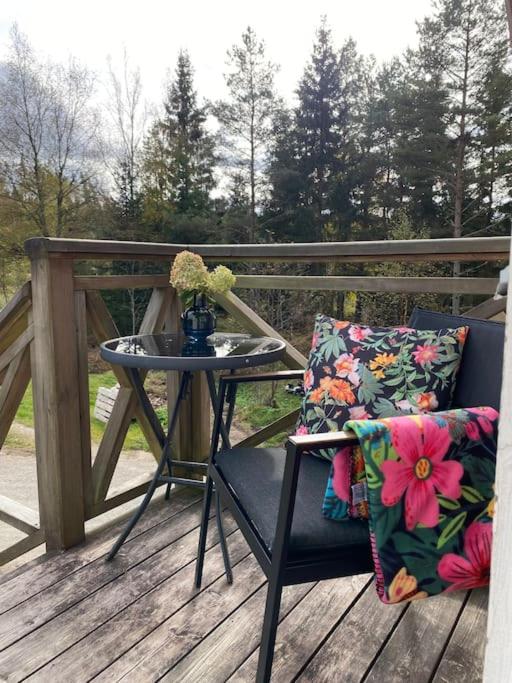 a table and a chair sitting on a deck at Lugnet på landet! in Töllsjö
