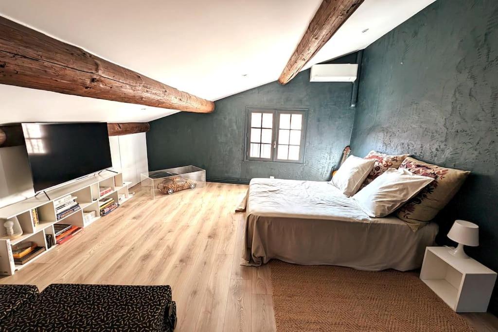 Cette grande chambre comprend un lit et une télévision. dans l'établissement Maison Ange & Lice, à Pernes-les-Fontaines