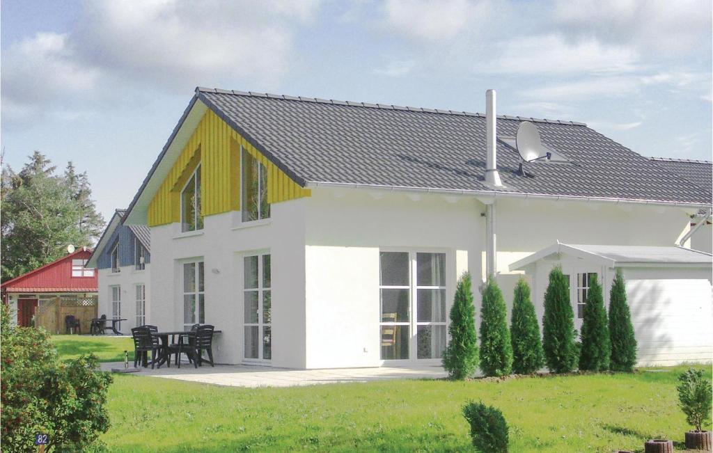a white house with a yellow and white roof at Seebrise in Süssau