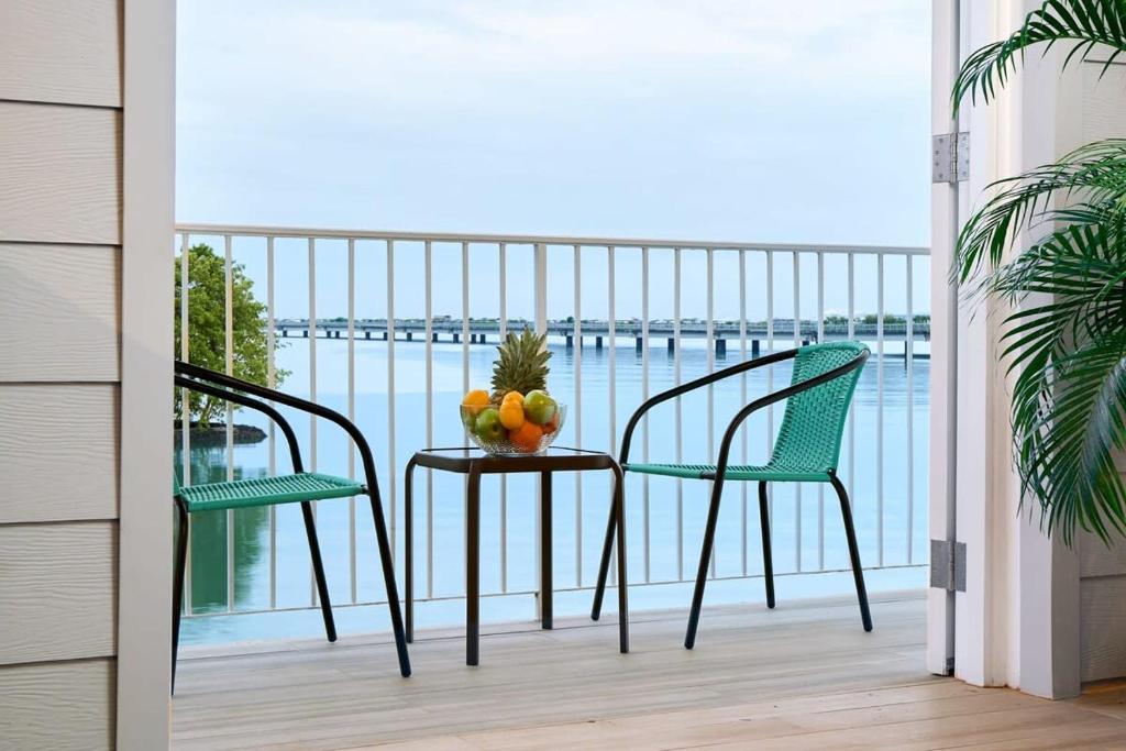 un balcón con 2 sillas y una mesa con fruta. en Casa La Costa By Wynwood House, en Panamá