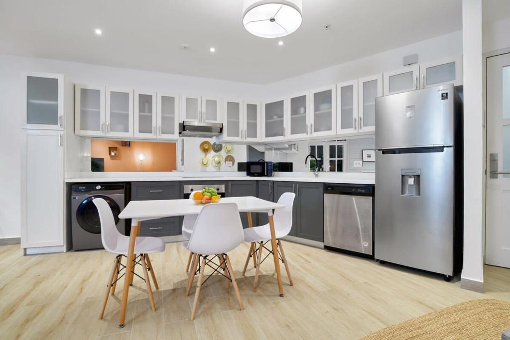 Una cocina con mesa y sillas y un refrigerador. en Casa La Costa By Wynwood House, en Panamá