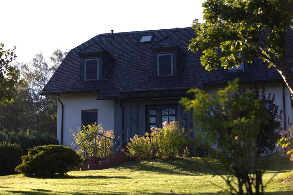 a white house with a black roof at Ferienwohnungen Adam Ries in Annaberg Buchholz in Annaberg-Buchholz