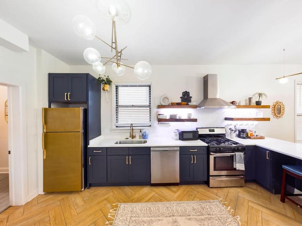 a kitchen with blue cabinets and a sink and a refrigerator at Chi-Town Ultimate Hideout 1-2-3 in Berwyn