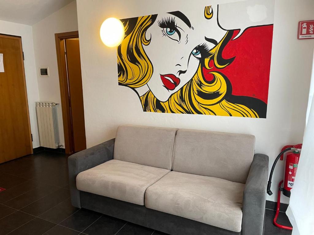 a living room with a couch and a painting of a woman at Cav Pop Sky in Seregno