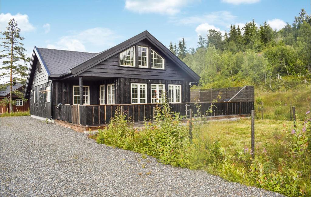 a black house with white windows and a fence at Lovely Home In Passebekk With Wifi in Omholt