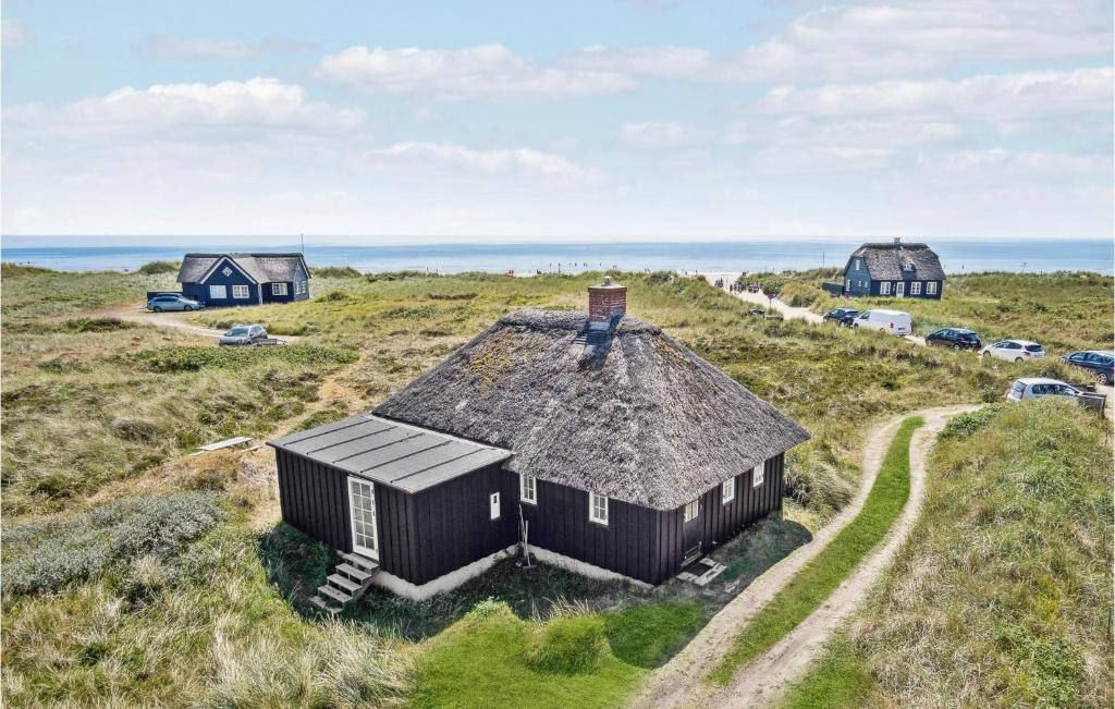 an old house with a thatched roof in a field at 3 Bedroom Gorgeous Home In Blåvand in Blåvand