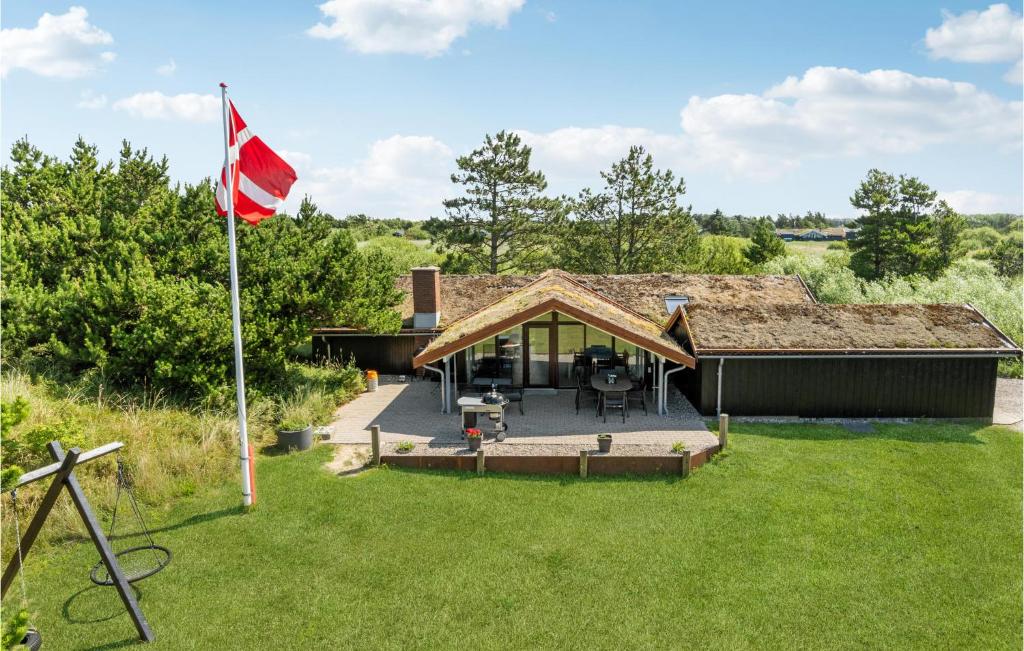 a house with a flag in the yard at Holiday Home Ringvejen X in Lakolk
