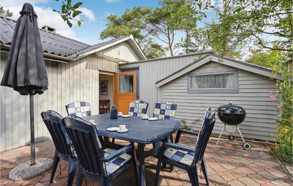 a patio with a table and chairs and an umbrella at Lovely Home In Hemmet With Wifi in Hemmet
