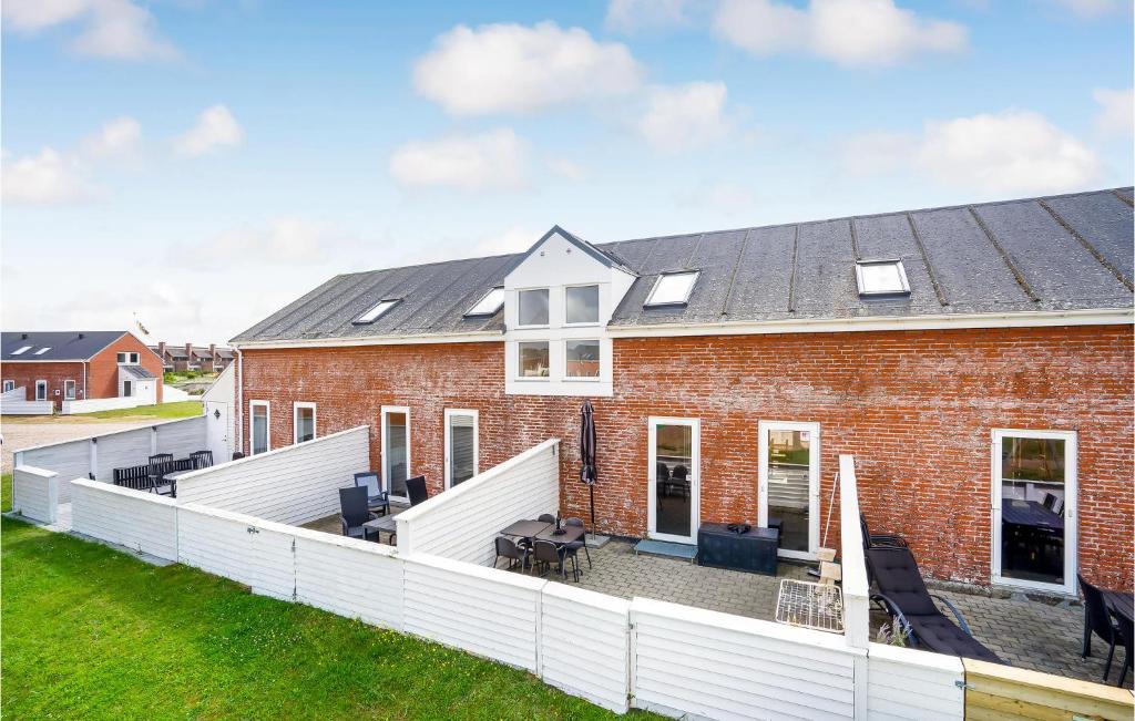 a red brick house with a white fence at Rim Rømø in Sønderby