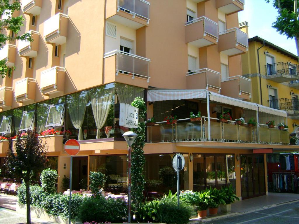 un bâtiment avec des balcons et des plantes sur son côté dans l'établissement Hotel Garisenda, à Misano Adriatico