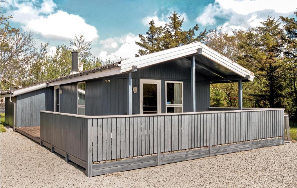 a black house with a fence around it at Holiday Home Hemmet 25 in Falen
