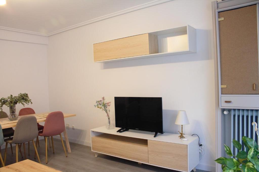 a living room with a flat screen tv on a cabinet at Apartamento LAS ABUBILLAS in Soria