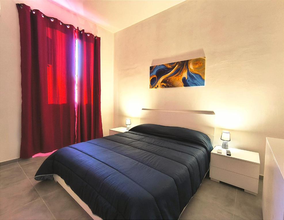een slaapkamer met een bed en een rood gordijn bij Casa Euripide in Siracusa