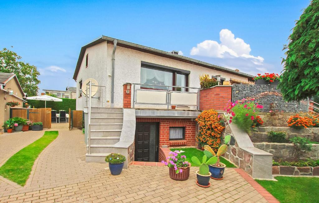 Ferienwohnung Waren Müritz في Warenshof: منزل مع شرفة وبعض النباتات الفخارية