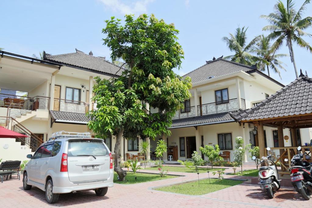 un coche blanco estacionado frente a una casa en Whiterose Guesthouse en Senggigi 