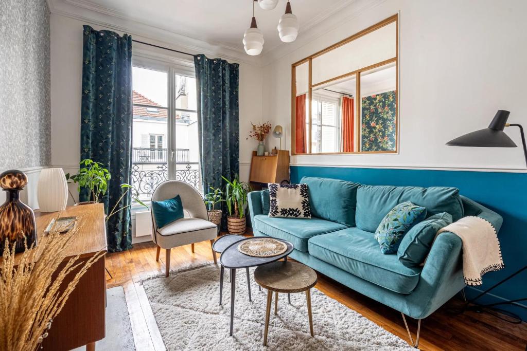 - un salon avec un canapé bleu dans l'établissement Appartement charmant à Paris 31 m² avec équipements modernes, à Paris