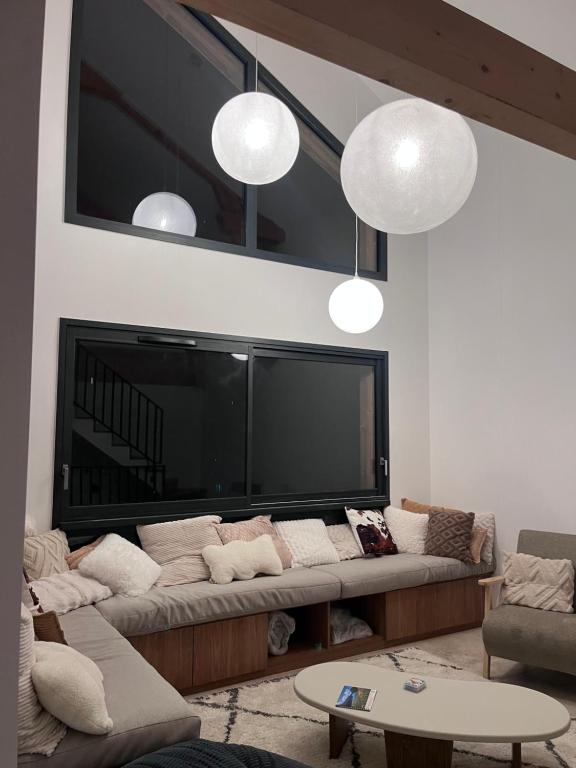 - un salon avec un canapé et une grande télévision dans l'établissement le petit ours, à Orcières