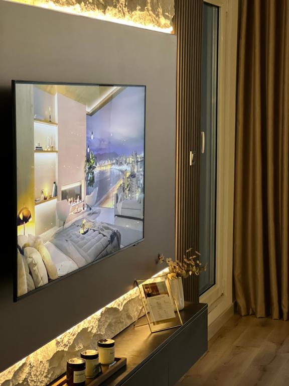 a living room with a tv on a wall at Stellarlux Apartment, 35th floor in Skopje