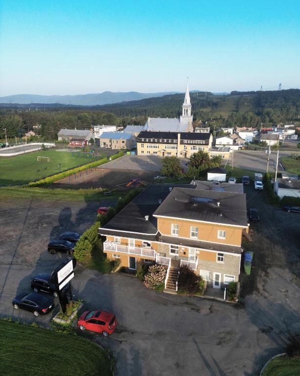 an aerial view of a building with cars parked in a parking lot at Auberge St-Tite-des-Caps in Saint-Tite-des-Caps