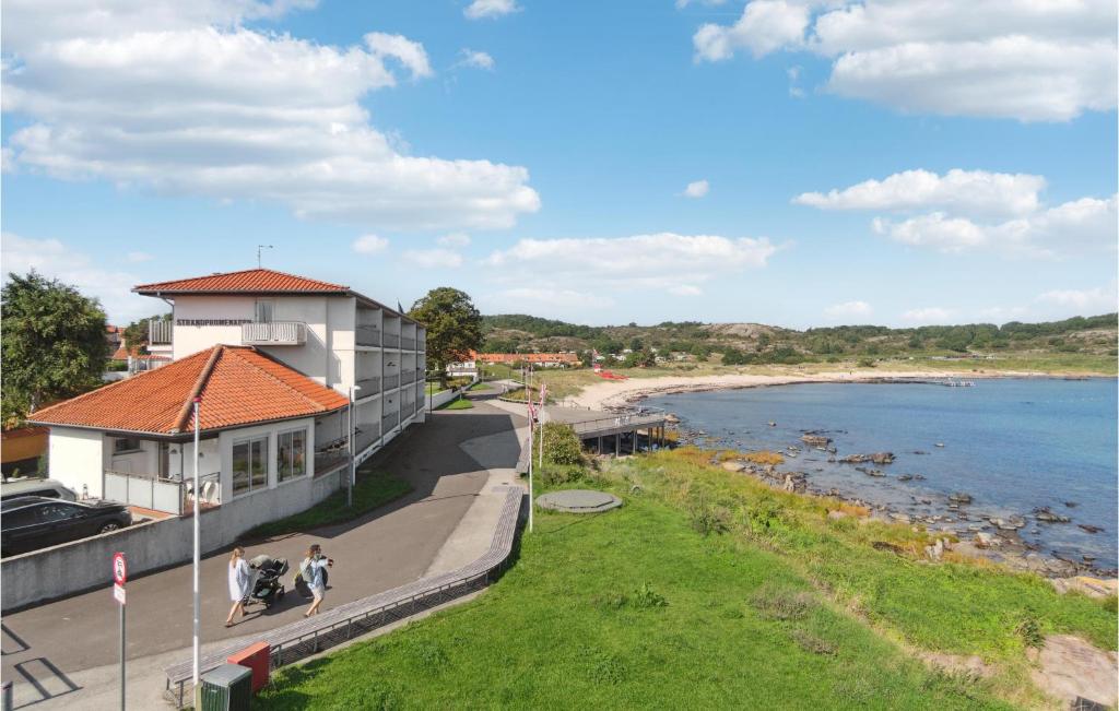 a building with people walking on a sidewalk next to a beach at Stunning Home In Allinge With Wifi in Allinge