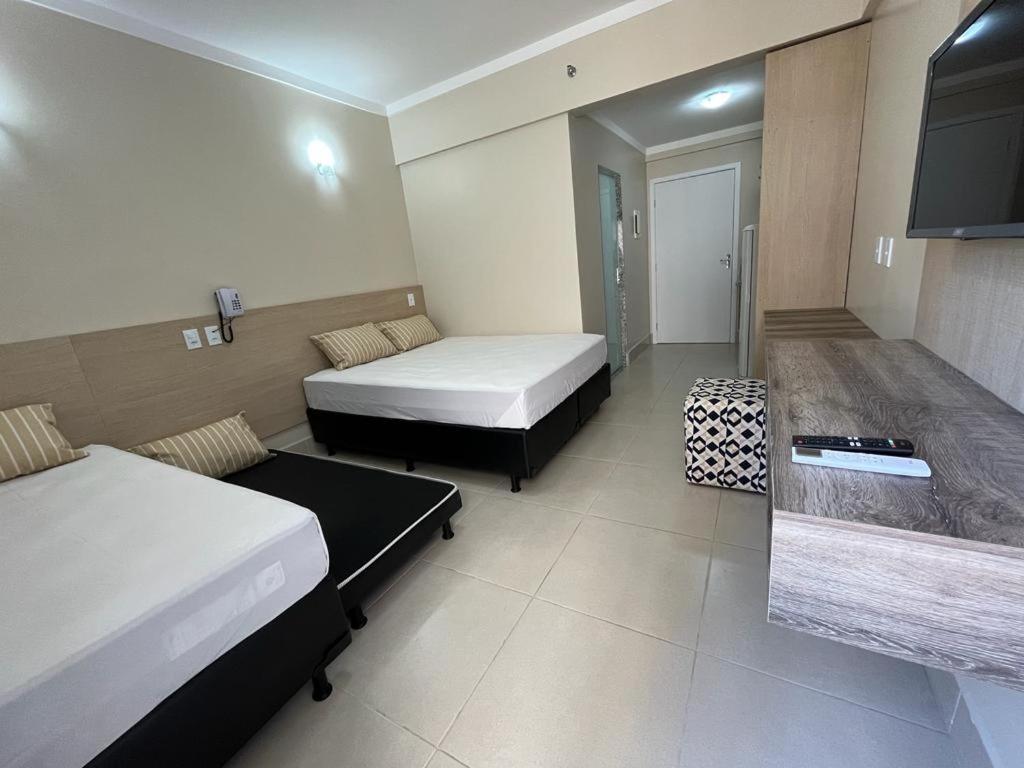 um quarto de hotel com duas camas e uma televisão em Spazzio diRoma Com Parque Acqua Park Diroma Incluso em Caldas Novas