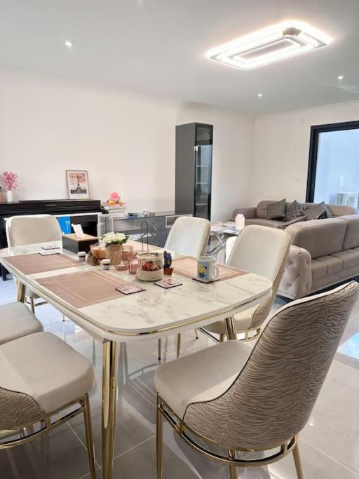 un salon avec une table, des chaises et un canapé dans l'établissement Maison familiale moderne aux portes de Paris, à Vitry-sur-Seine