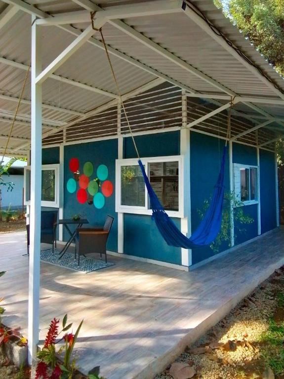 a blue house with a hammock on a patio at Luz Tropical in Puerto Viejo