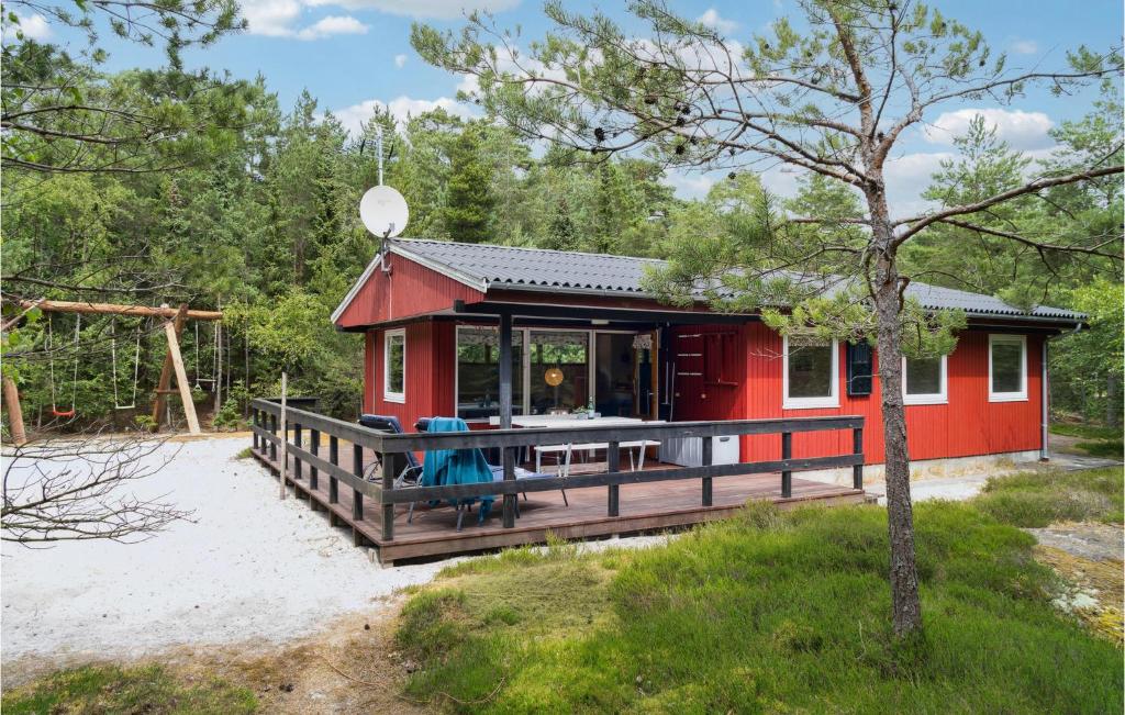 ein rotes Haus mit einer Terrasse im Sand in der Unterkunft Holiday Home Hc Møllersvej Nexø in Bedegård