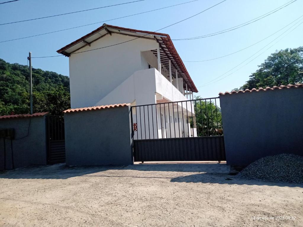 a white house with a gate and a fence at Kitnet da Adriana in Paraty