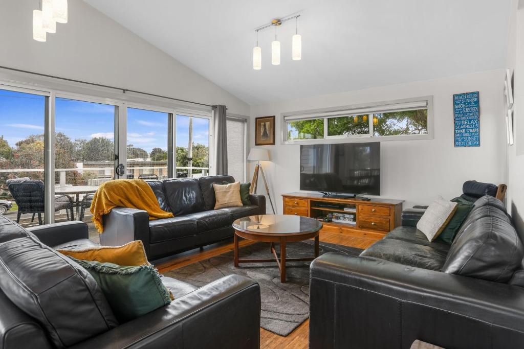 ein Wohnzimmer mit Ledersofas und einem TV in der Unterkunft Number 6 at The Bay in Apollo Bay