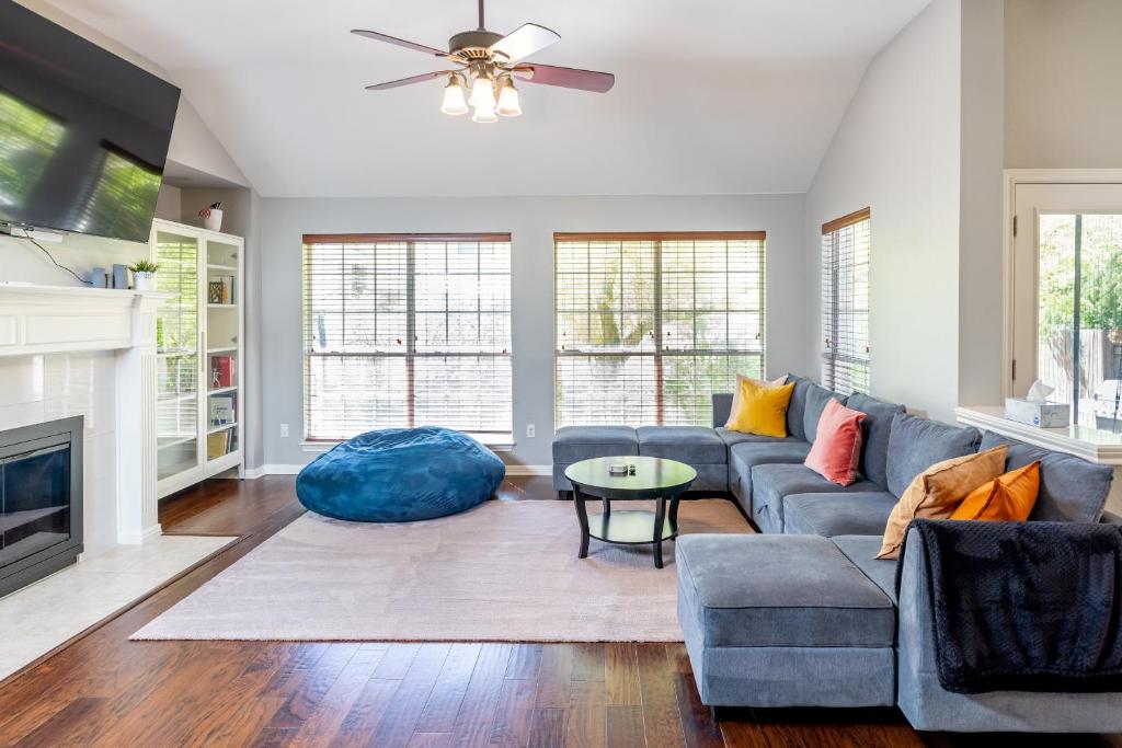 a living room with a blue couch and a table at Spacious 4BR Home Away From Home with Hot Tub in Austin