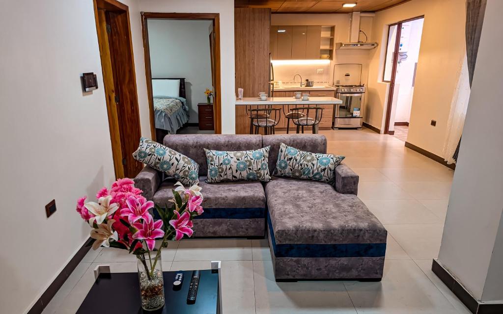 a living room with a couch and a vase of flowers at Departamento en centro de Cuenca in Cuenca