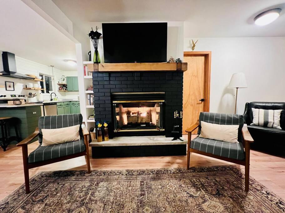 ein Wohnzimmer mit einem Kamin und einem Flachbild-TV in der Unterkunft Cozy Cottage by the Lake in Albrightsville