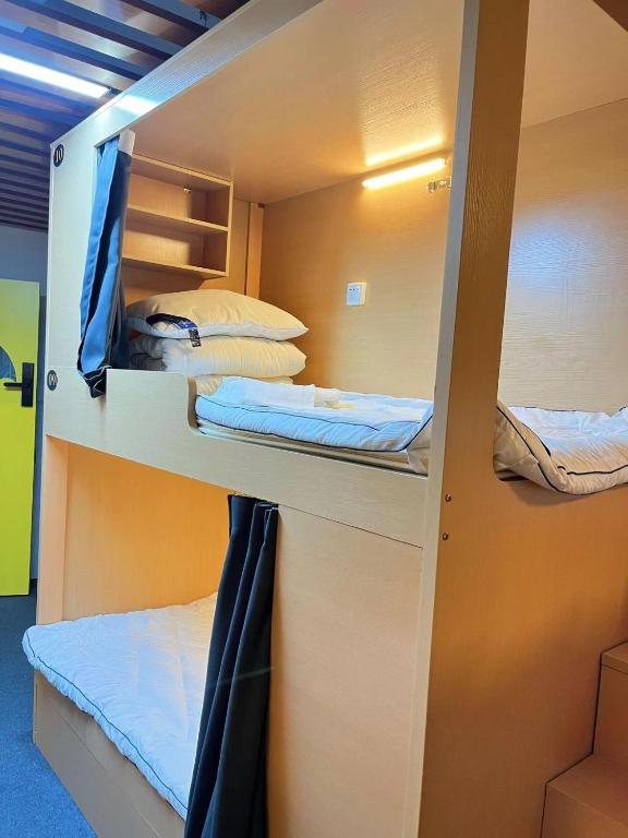 Postel nebo postele na pokoji v ubytování Zhihexing Youth Hostel-知和行青年酒店