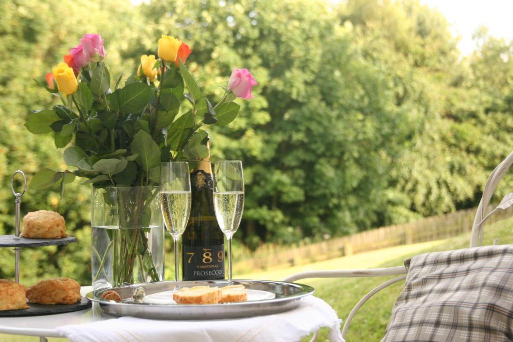 a table with a vase of flowers and glasses of wine at The Fairways in Stanley