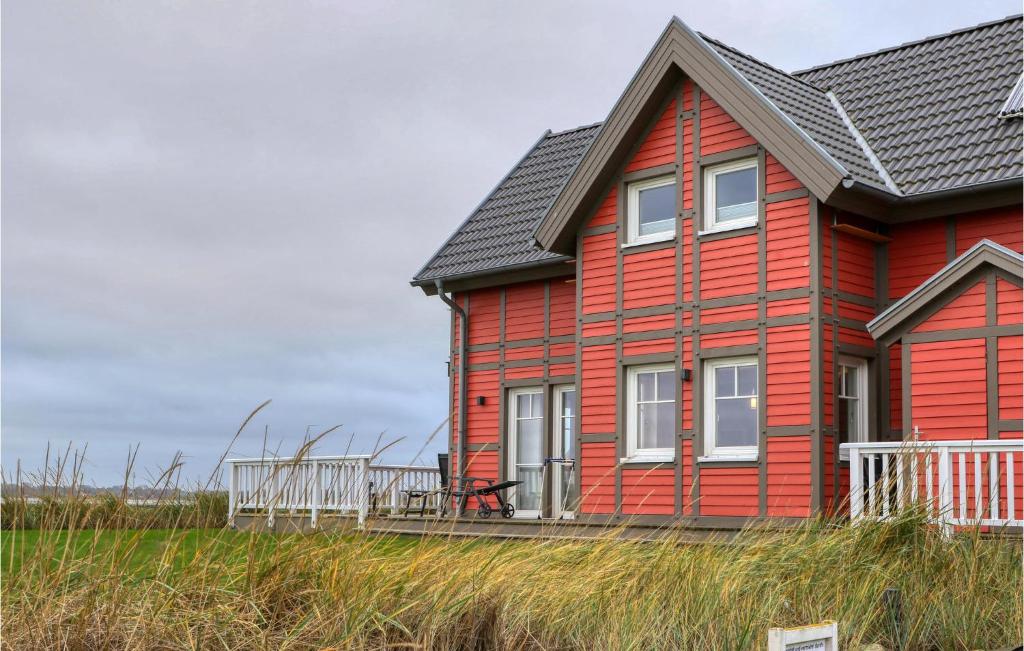 a red house with a black roof at Unendliche See in Olpenitz