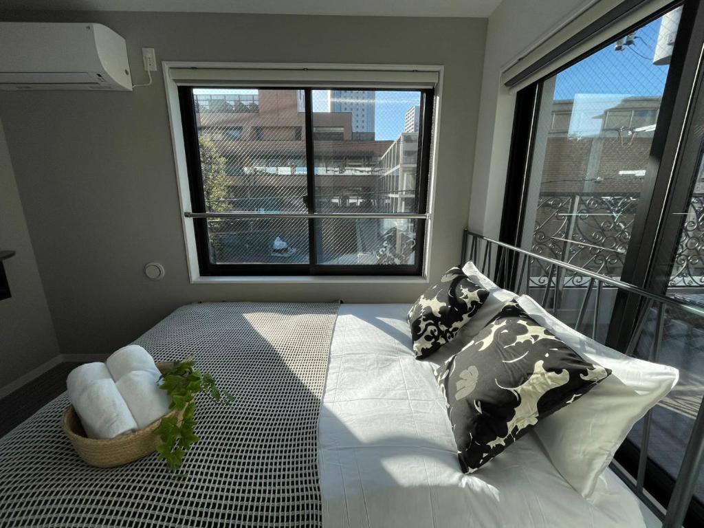 a bedroom with a bed and a large window at COMMA HOUSE Shinjuku 303 in Tokyo