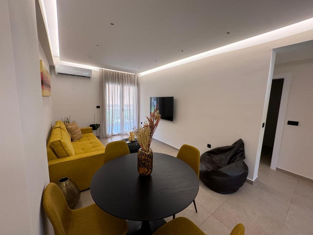 een woonkamer met een tafel en een gele bank bij Resort Beach Living in Lagonisi in Kalívia Thorikoú