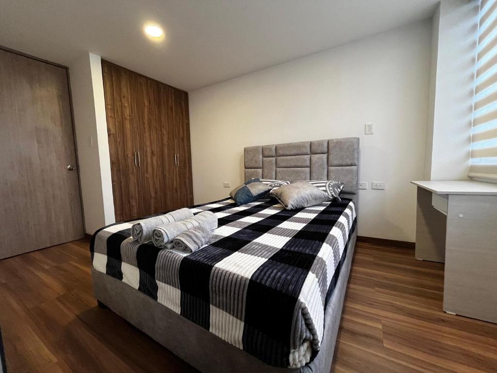 a bedroom with a bed with a black and white blanket at Apartamento de una habitación in Pasto